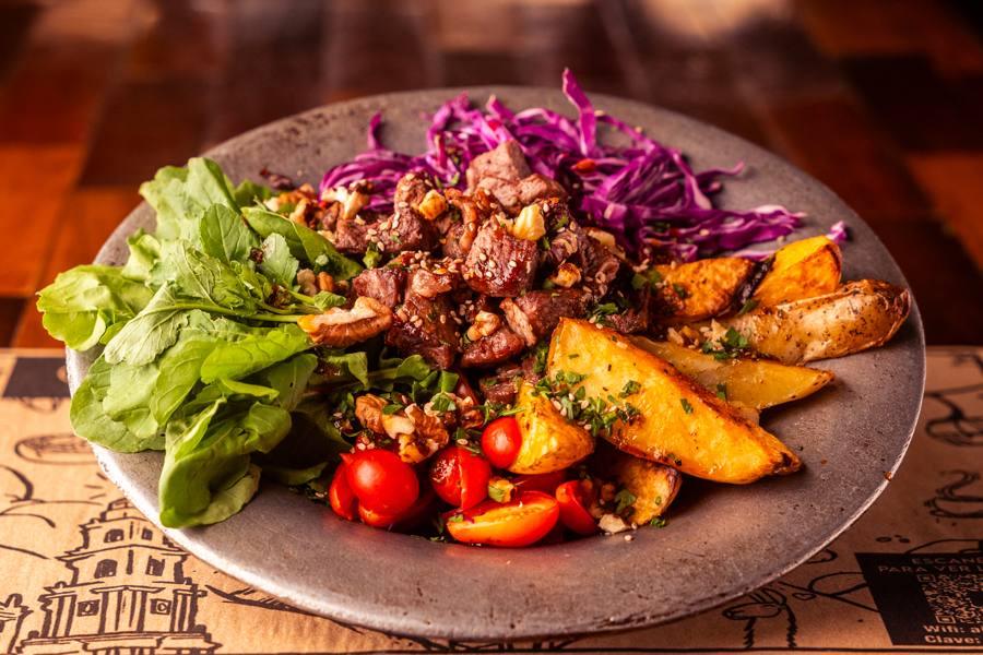 Plato con ensalada fresca y papas rústicas
