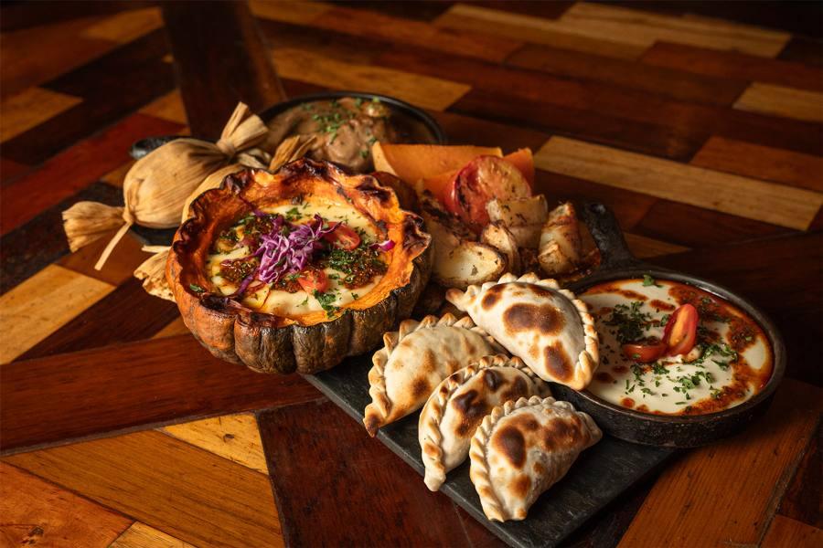 Tabla con empanadas y cazuelas para compartir