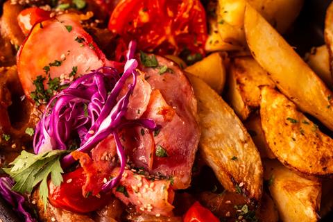 Primer plano de las papas especiadas doradas junto a la panceta